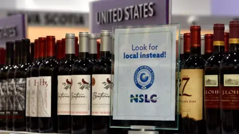 Reuters A "Look for local instead" sign displayed on a shelf with wine at a Canadian liquor shop.