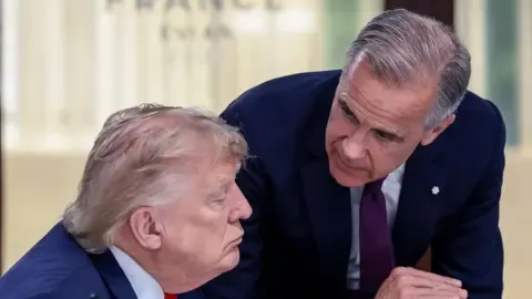 Getty Images US President Donald Trump (left) speaks with Canada's Prime Minister Mark Carney during a work lunch as part of the G7 summit,…
